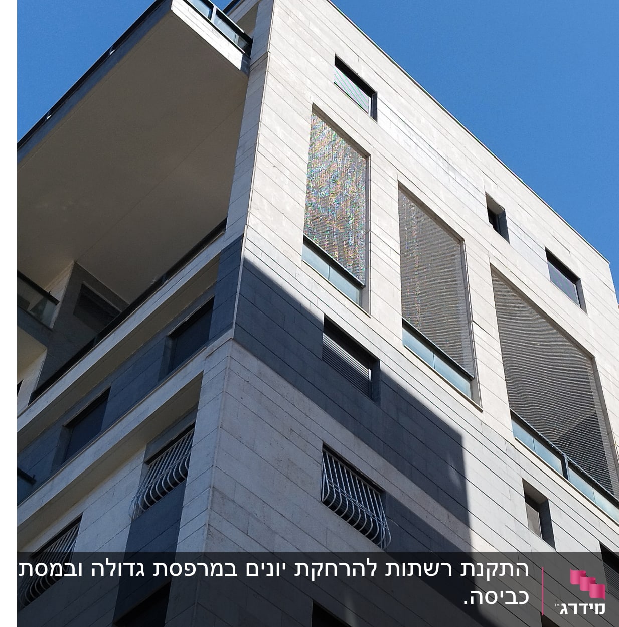 בניין עם רשתות על חלונות למניעת כניסת יונים